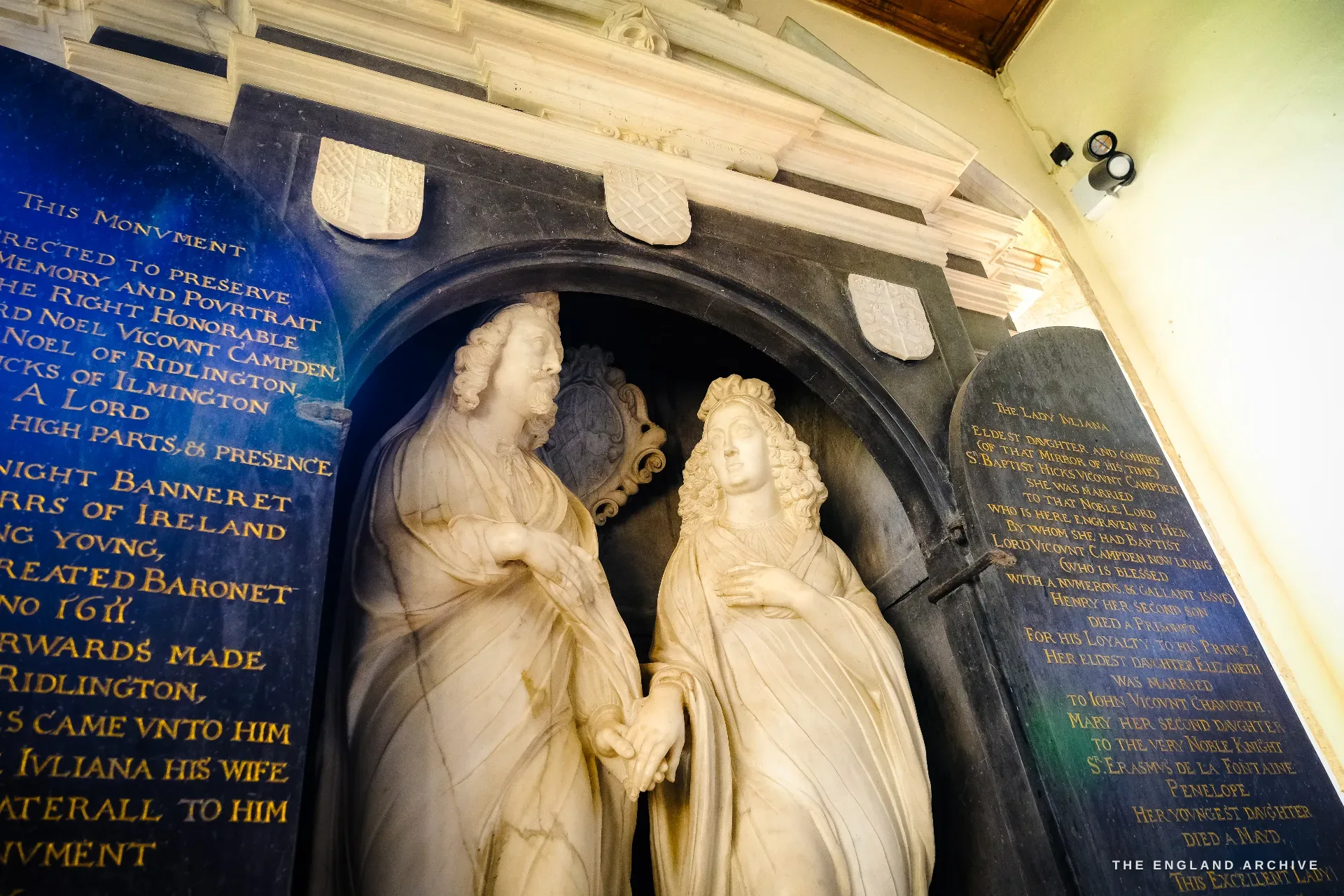 The standing marble monument to Edward Noel, Viscount Campden, and his wife Lady Juliana, two figures facing each other under an arch flanked by two inscribed tablets.