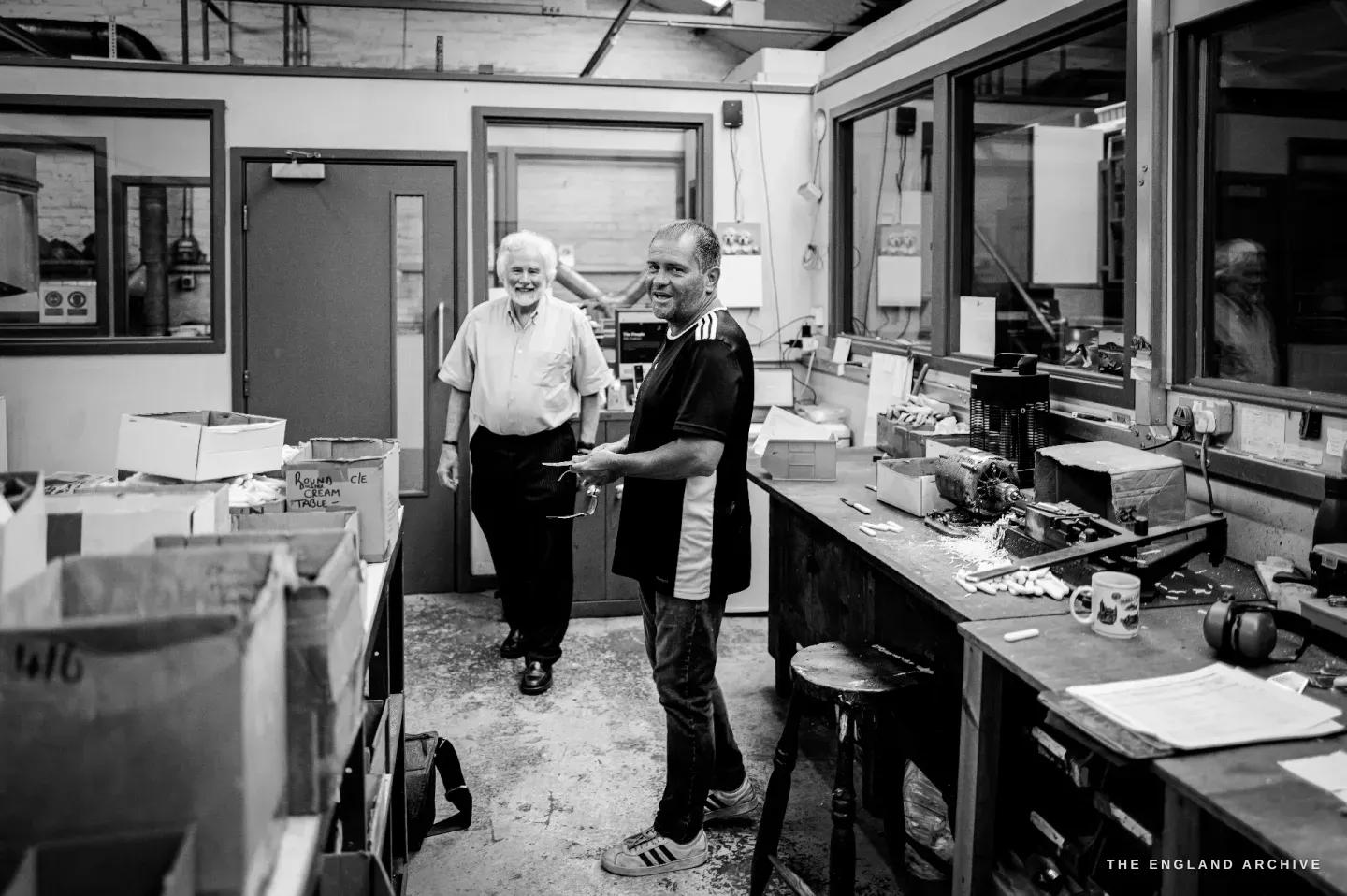 Chris Hudson and Paul Weatherstone standing together in the finishing room, both smiling, mid-conversation.