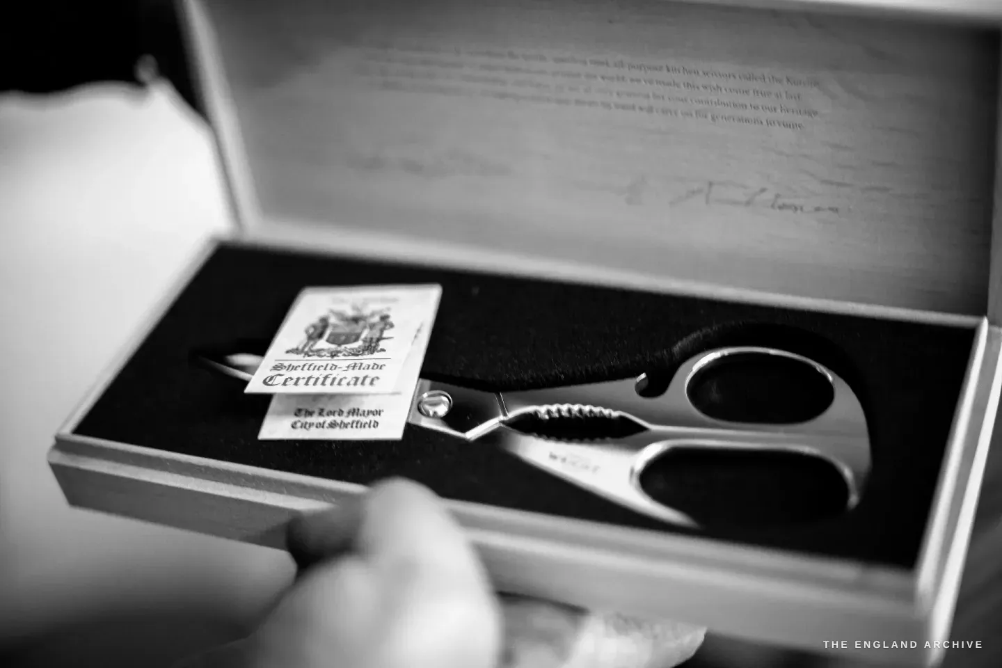 A Kutrite kitchen scissors resting in a wooden presentation box beside a Sheffield-Made Certificate from the Lord Mayor of Sheffield, the engraved lid signed inside.