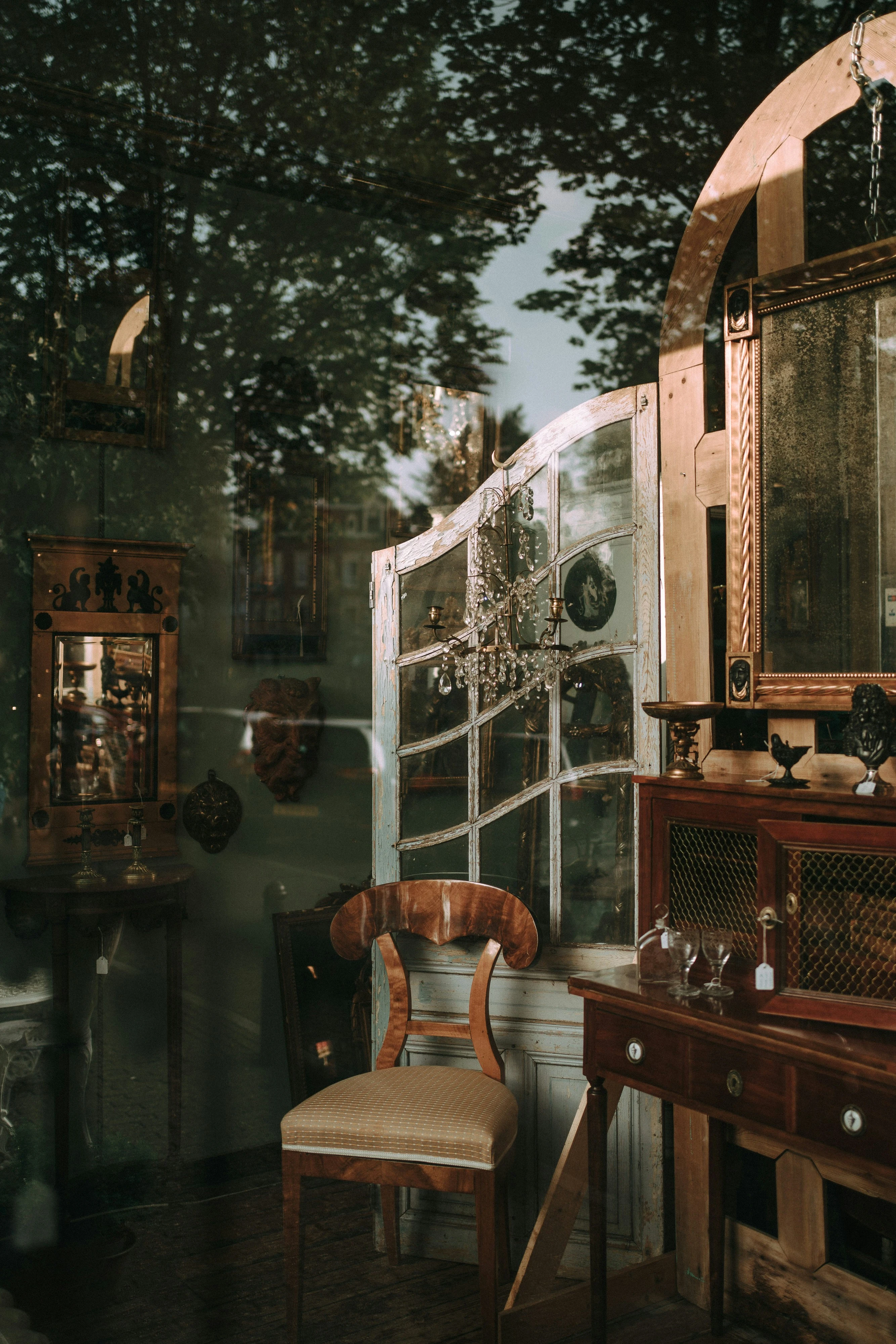 Antique furniture and collected objects seen through glass