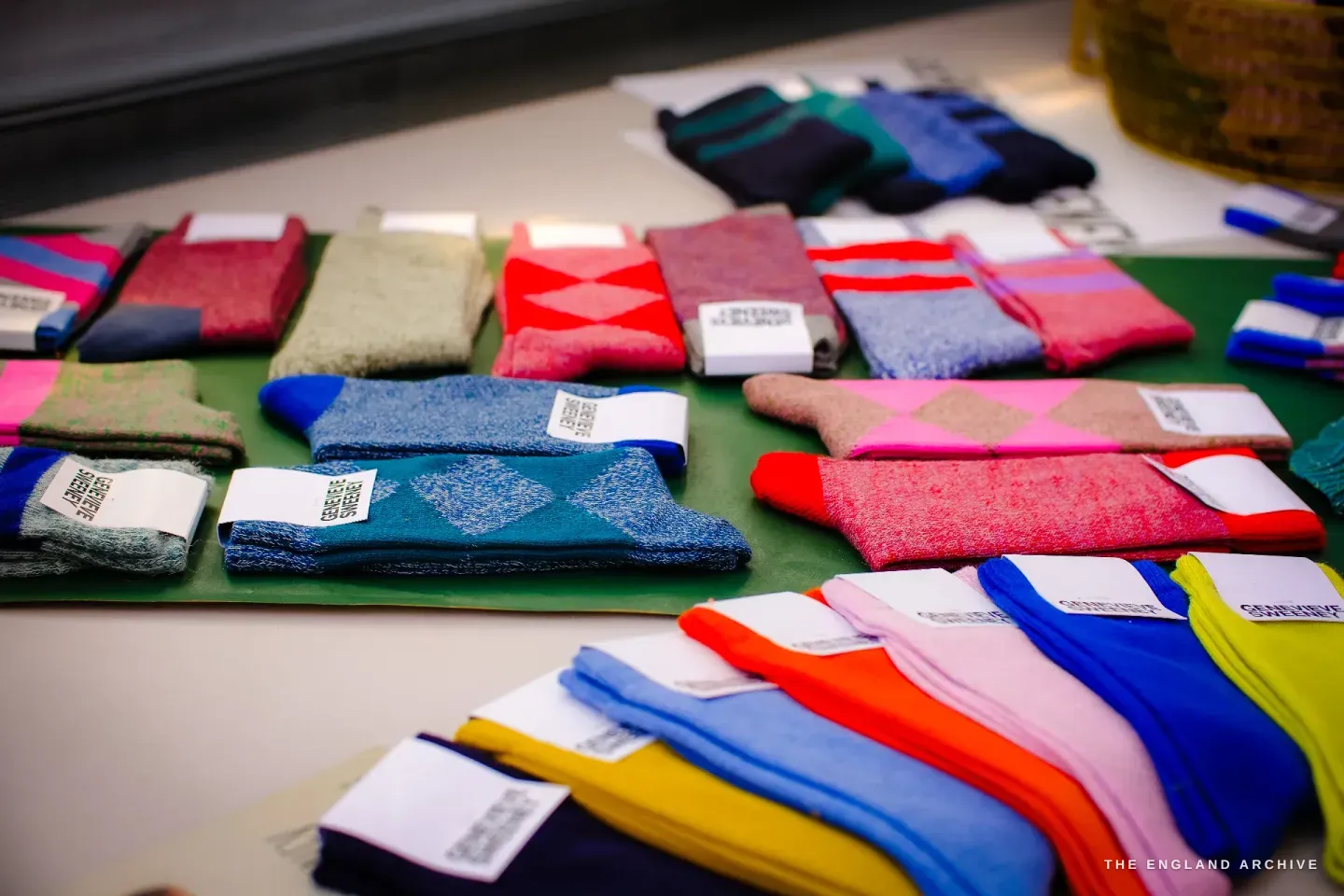 Rows of folded socks with paper bands, in argyle, stripe and solid patterns across every colour.