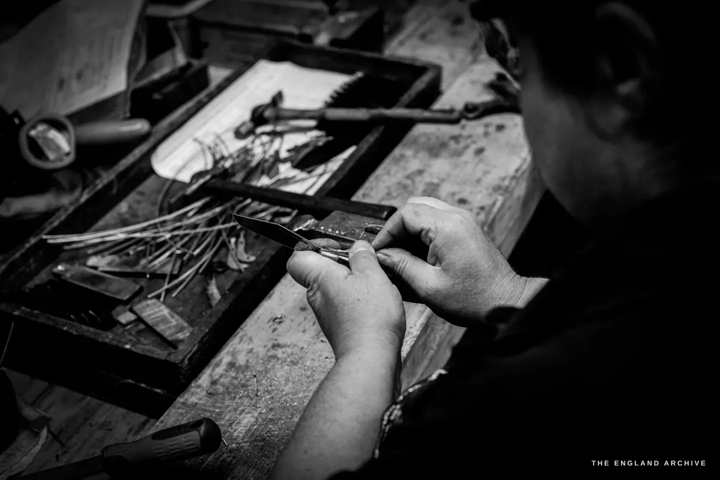 Over Kylie Cocker&rsquo;s shoulder, her hands fit a tiny blade into a knife on the bench beside a tray of slender springs.