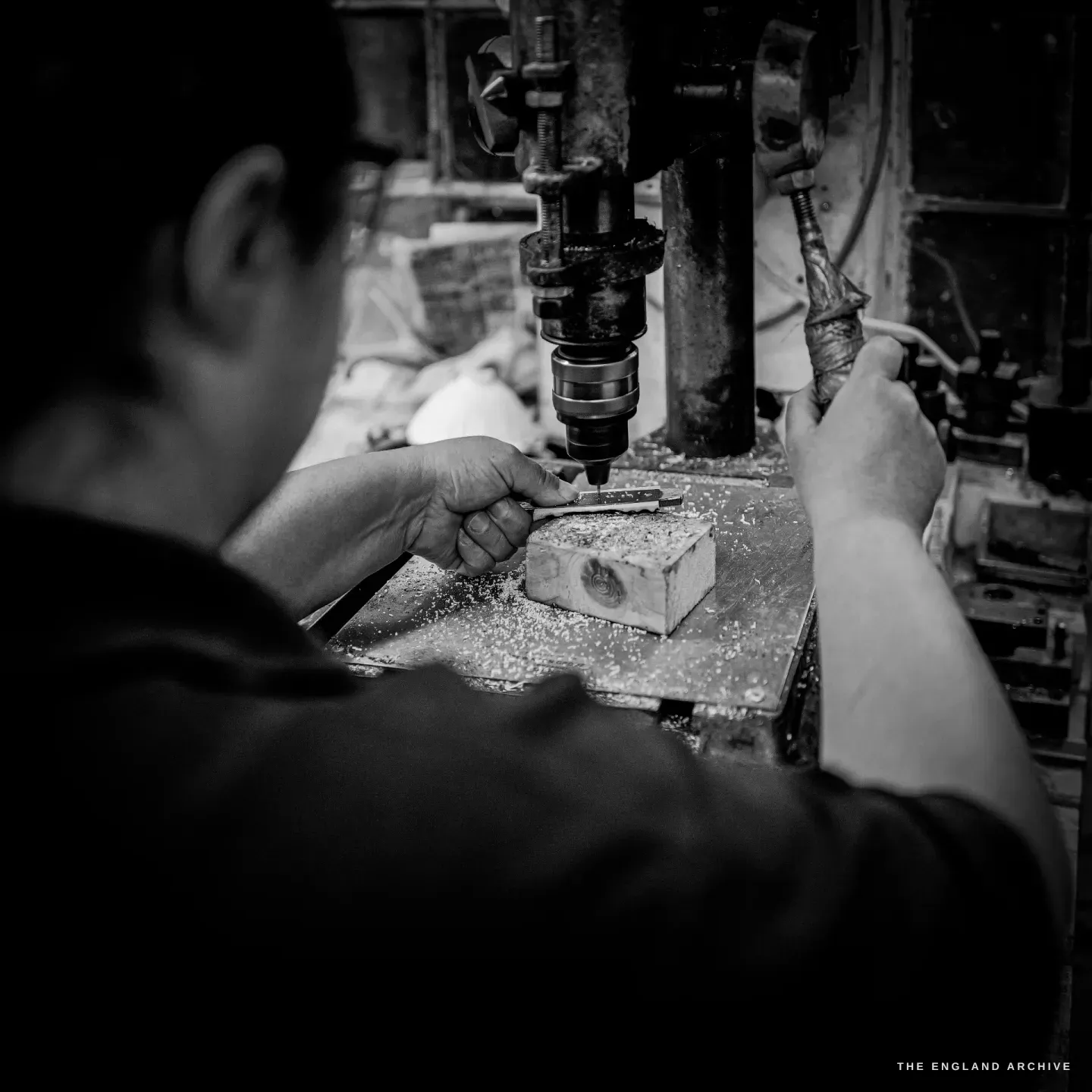 Over Kylie Cocker&rsquo;s shoulder, the pillar drill&rsquo;s bit descends onto a small block held on the table.