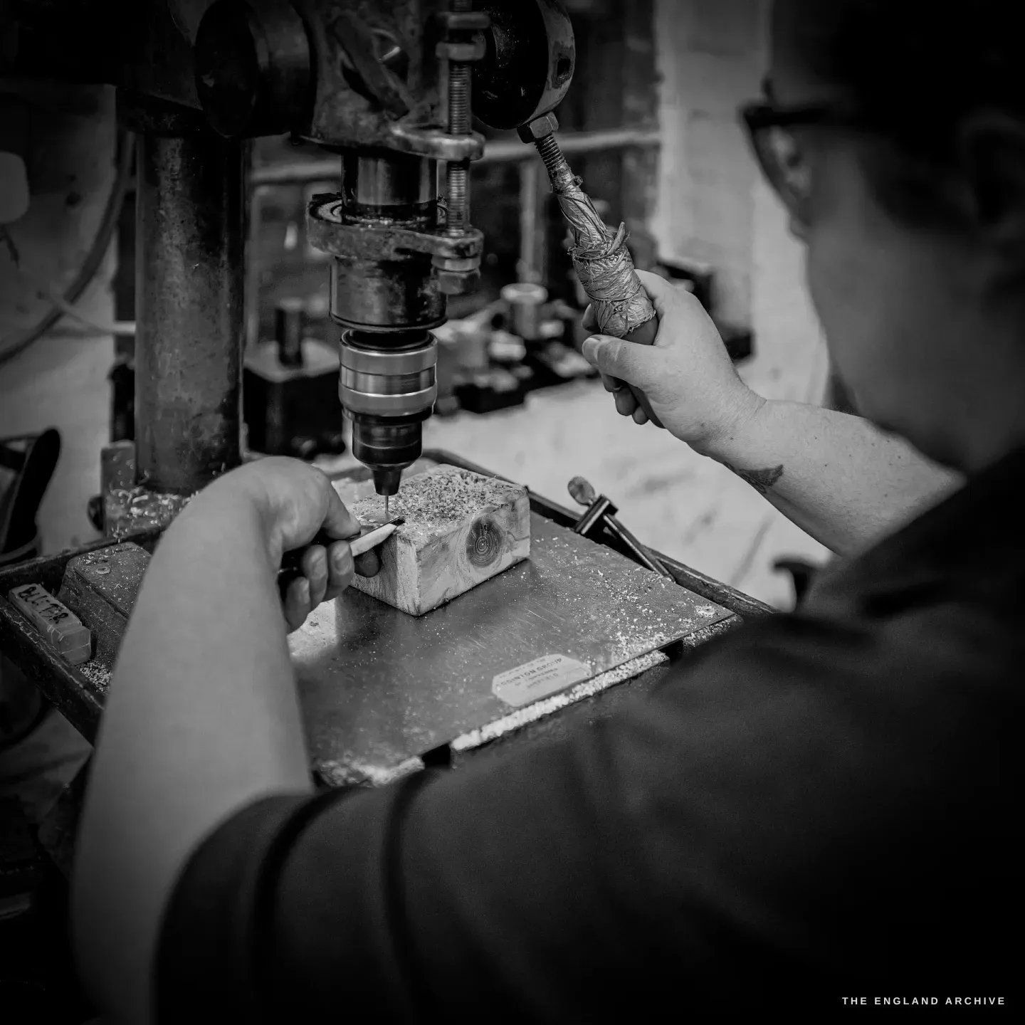 Kylie Cocker holds a component to the pillar drill, a twist of swarf around the bit.