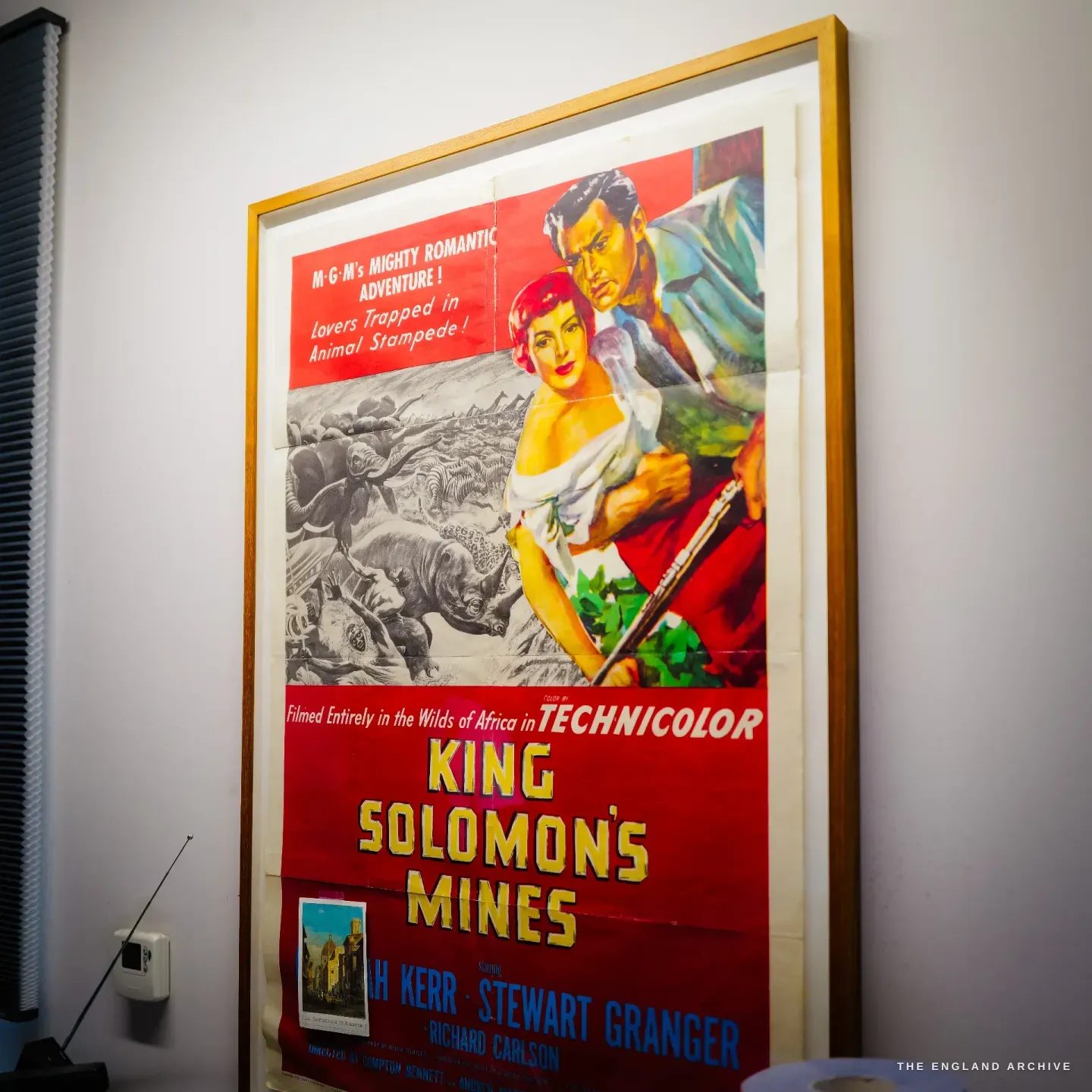 A framed vintage Technicolor film poster for KING SOLOMON'S MINES hangs on the studio wall.