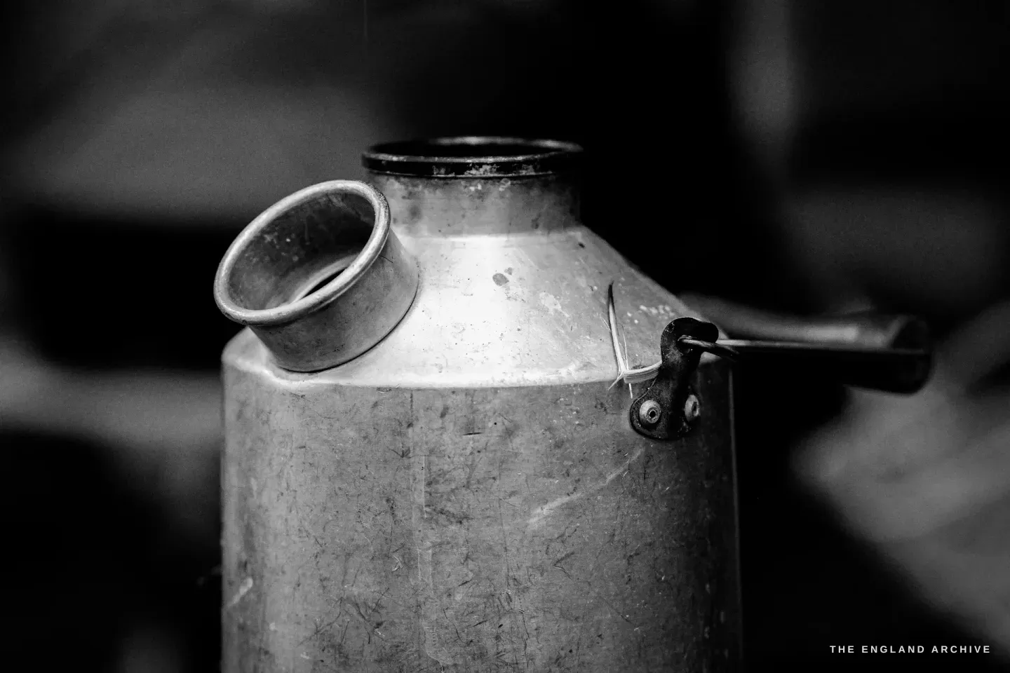 Close-up of the Kelly Kettle’s aluminium body and its angled spout, the chimney still warm, the working metal scratched and dull from years of fires.