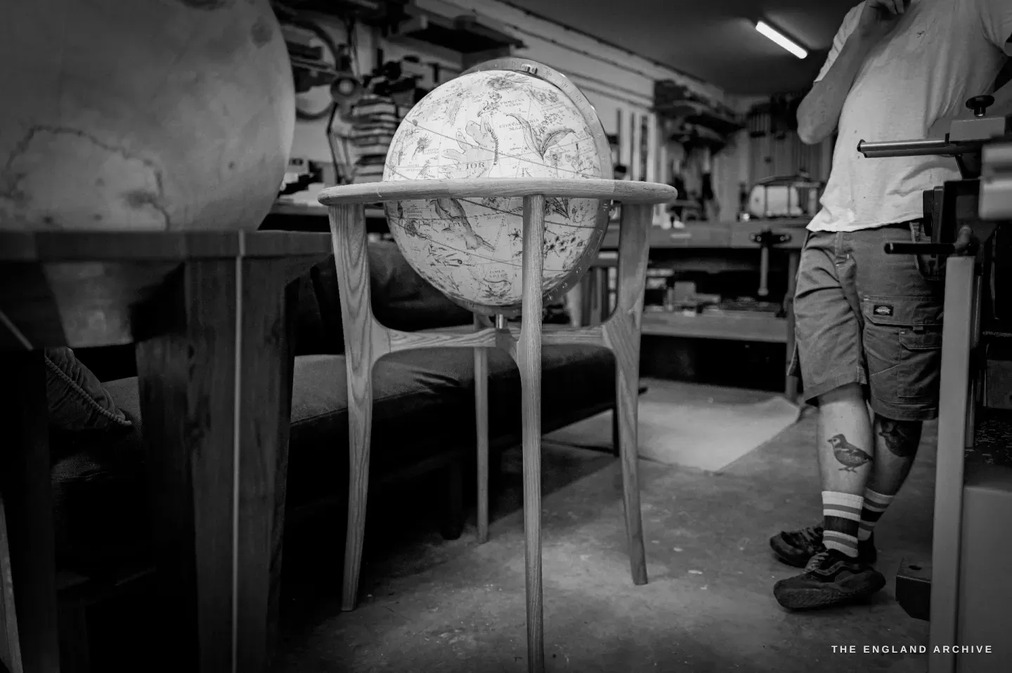 A celestial globe on a slender four-legged wooden stand of his own design, in the workshop, with another globe beside it.