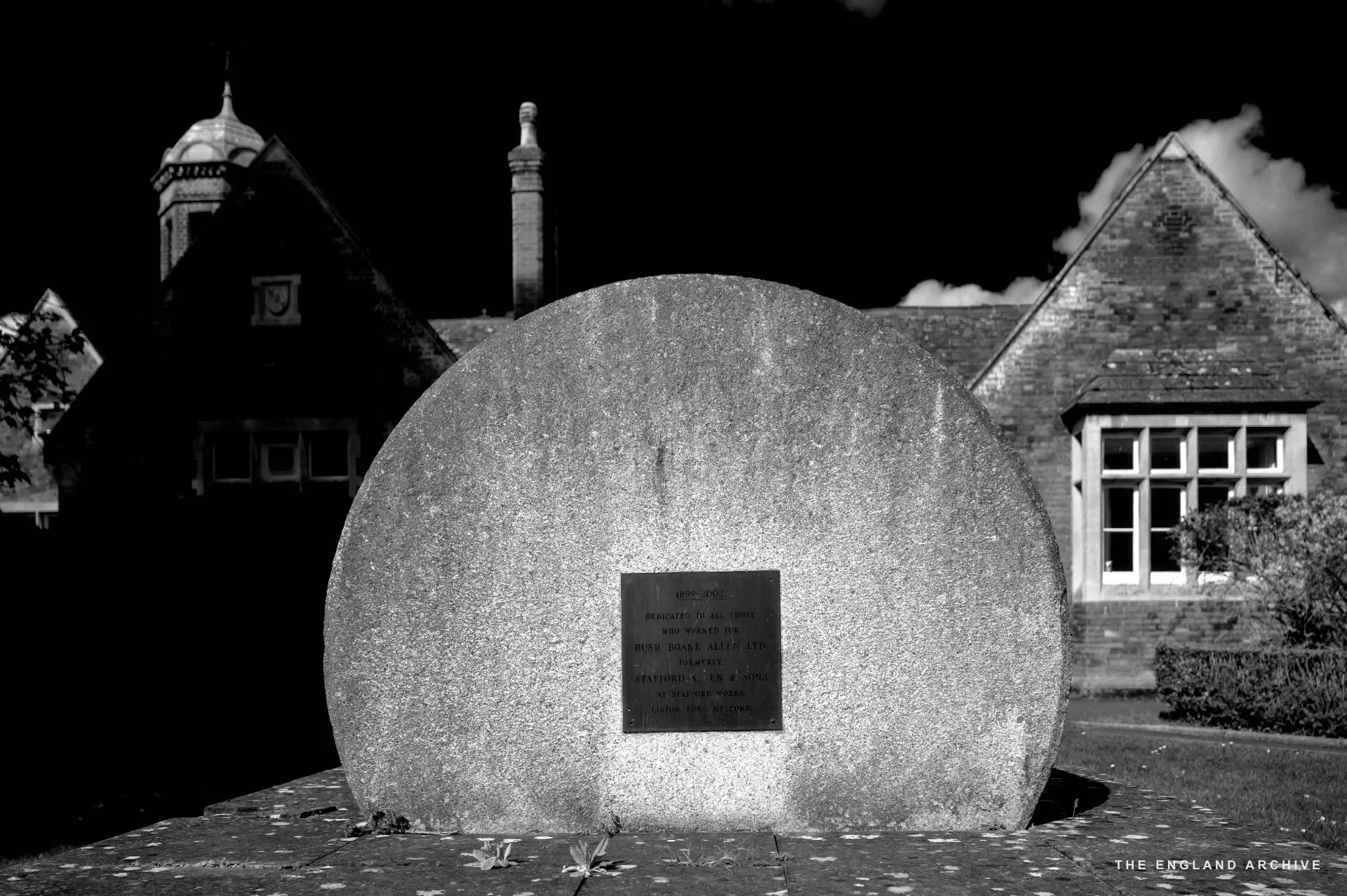 A close view of a circular stone memorial plaque set into the ground in front of the Old School.