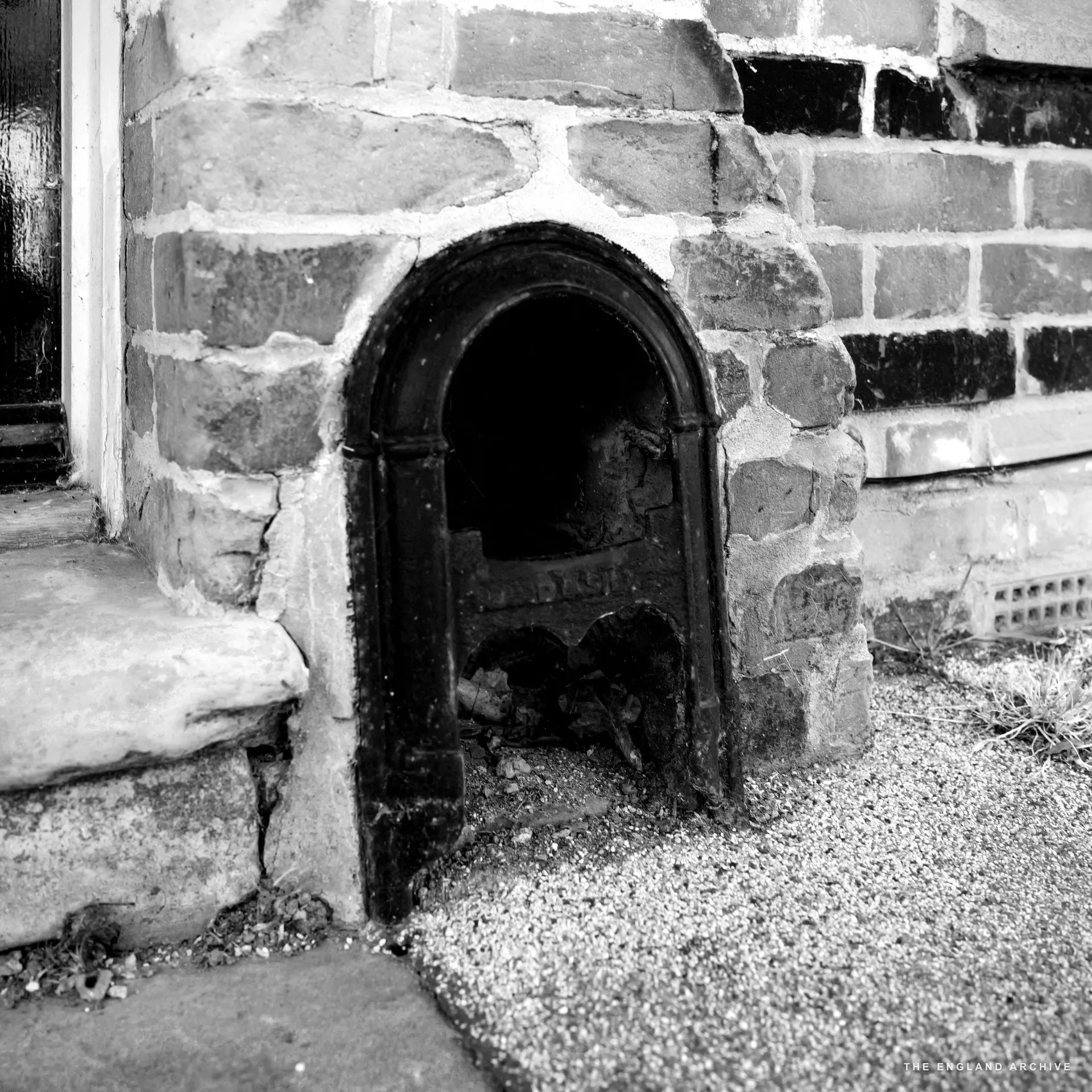 The Blackwell &amp; Co deli from the front, a grey-bearded man in a red check shirt emerging from the doorway with wooden produce crates outside.