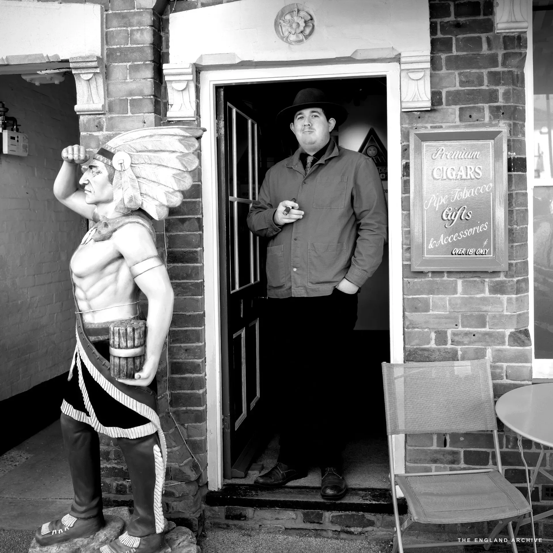 A close-up of a cast-iron air-brick vent set into the base of a brick wall.