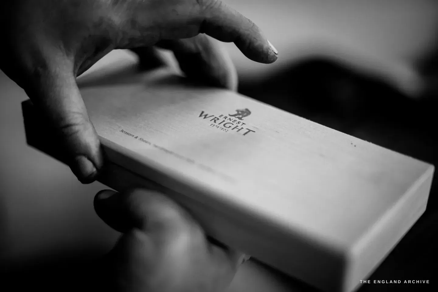 A hand holding a wooden Ernest Wright presentation box, the maker’s mark and EST 1902 burned into the lid.