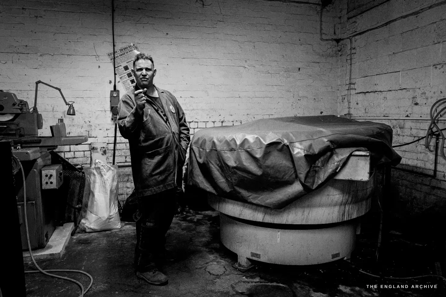Neil at his bench turning a pair of scissors in his hands, checking the action, tools and parts spread in front of him.