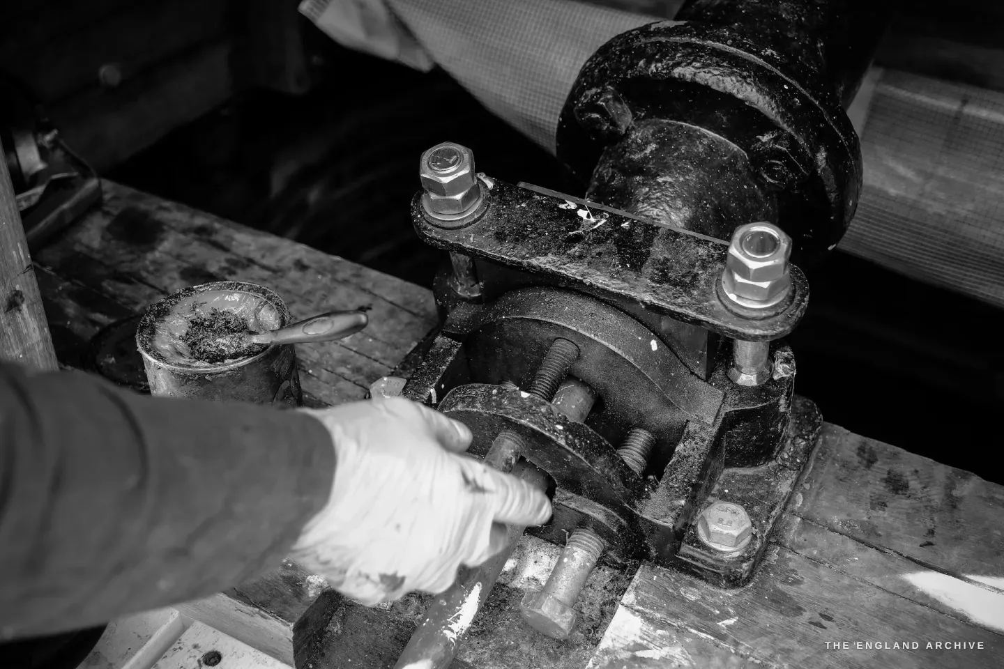 Close-up of Paul's hand greasing an iron bearing mechanism