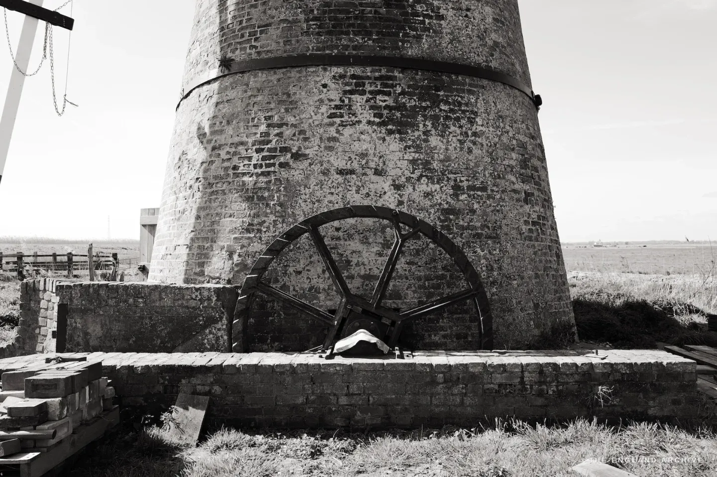 The external scoop wheel at the base of the mill, iron wheel against weathered brickwork