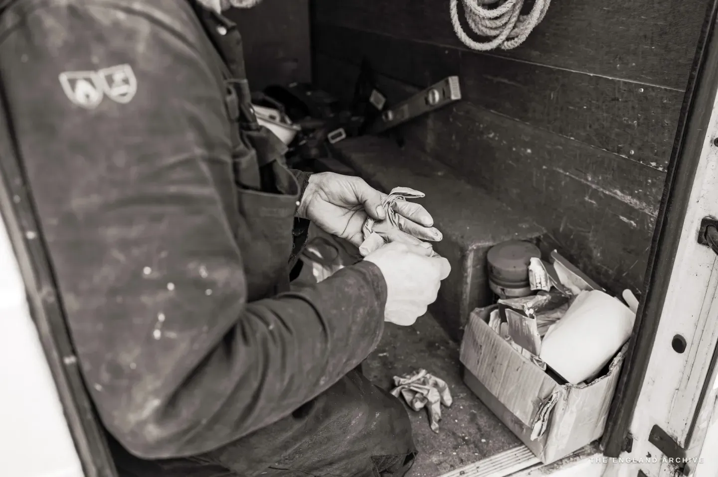 Paul Kemp's hands at rest, weathered and capable, resting on the timber of the mill