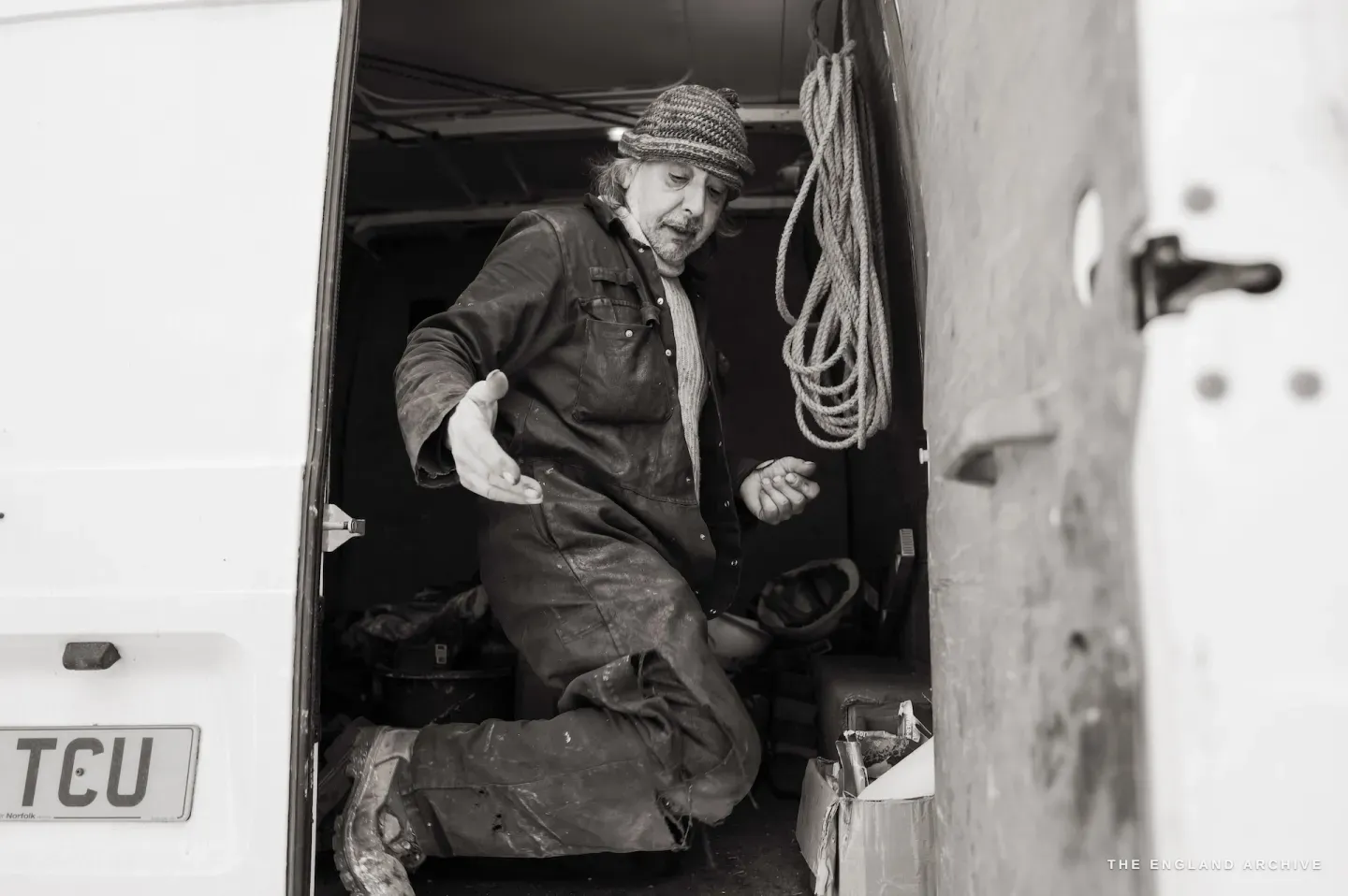 Paul Kemp climbing out of the back of his work van, ropes coiled behind him, smiling