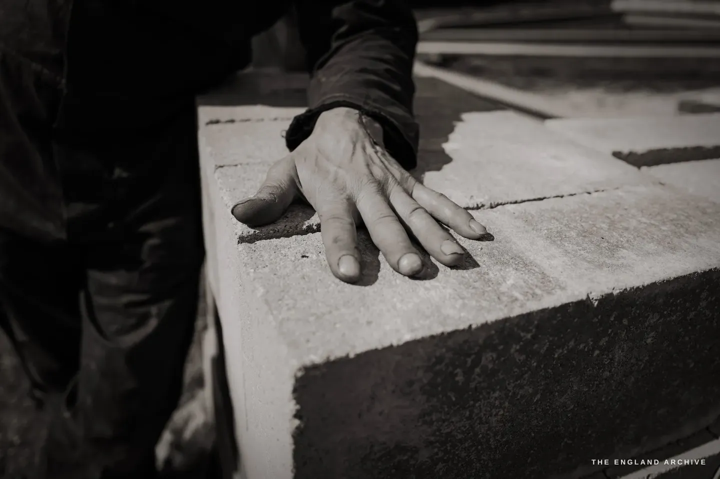 Paul Kemp's hand resting flat on stone, the skin weathered and capable