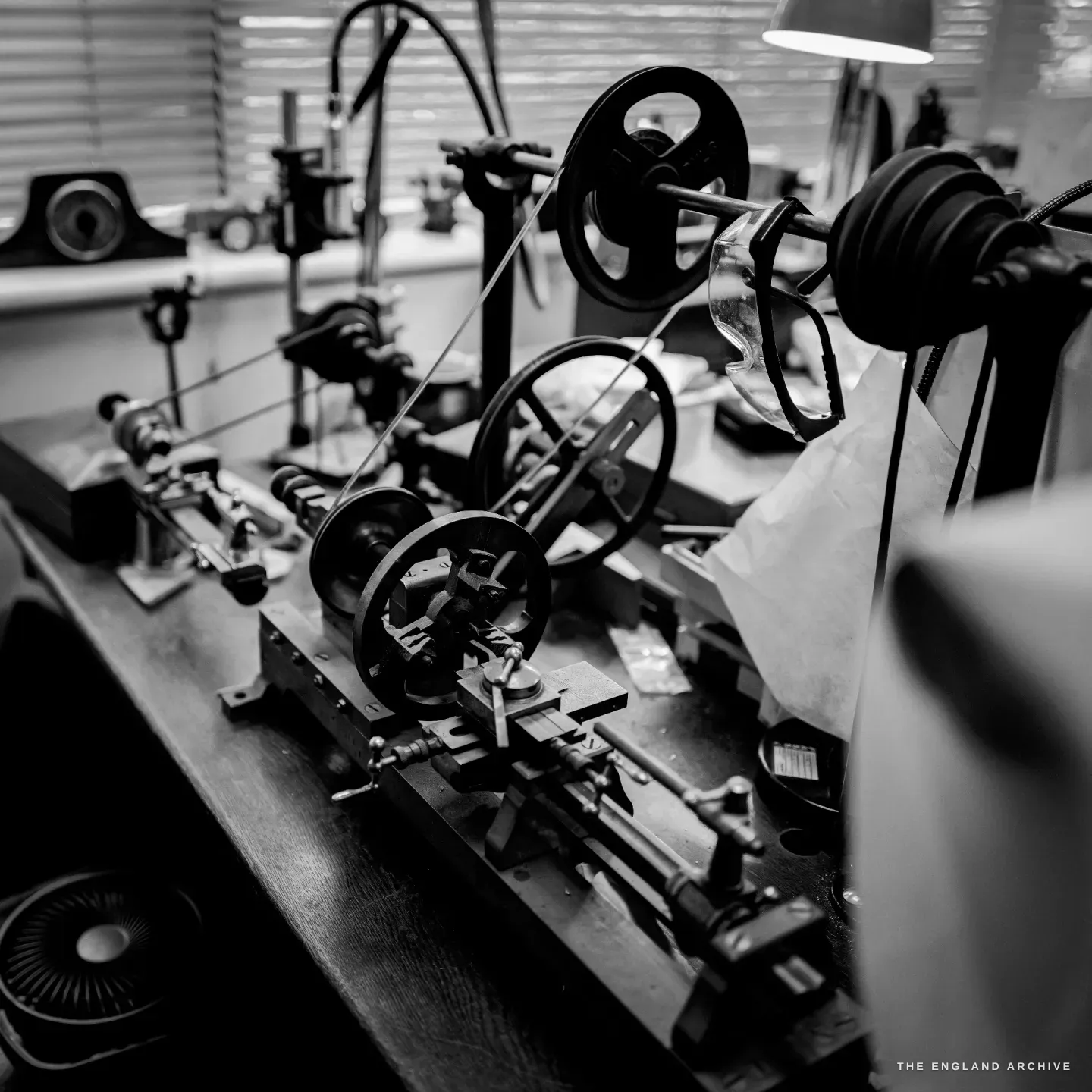 The straight-line engine seen with its overhead line-shaft, pulley wheels and drive belts, flywheels and slide rest on the bed.