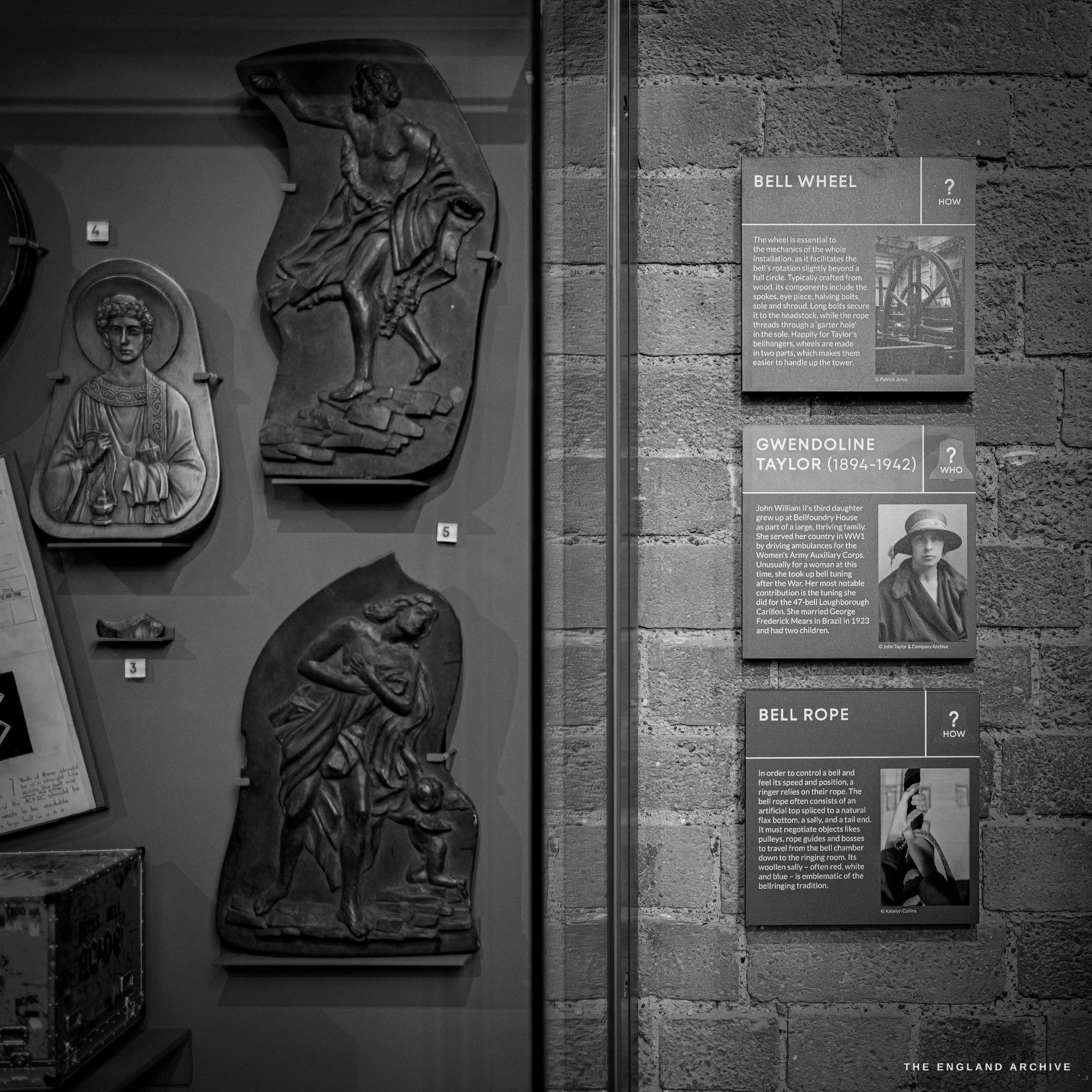 Cast relief patterns of saint figures on the left and interpretation panels on the right brick wall, one carrying a portrait of Gwendoline Taylor.