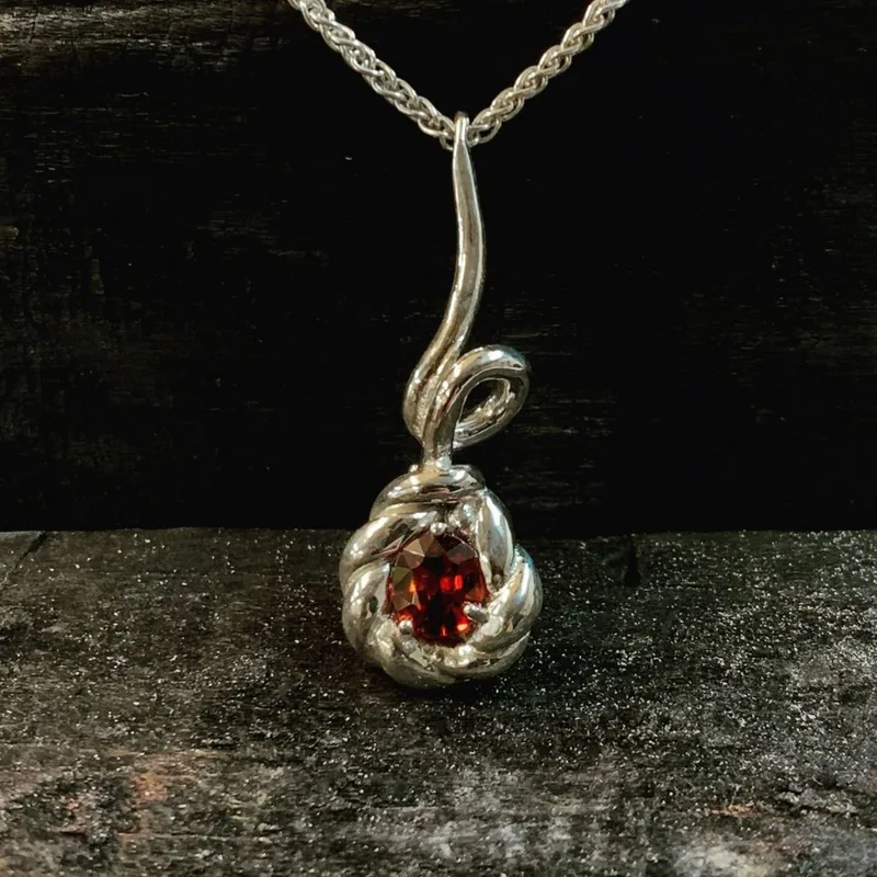 The Twist Garnet ring in silver set with a garnet.