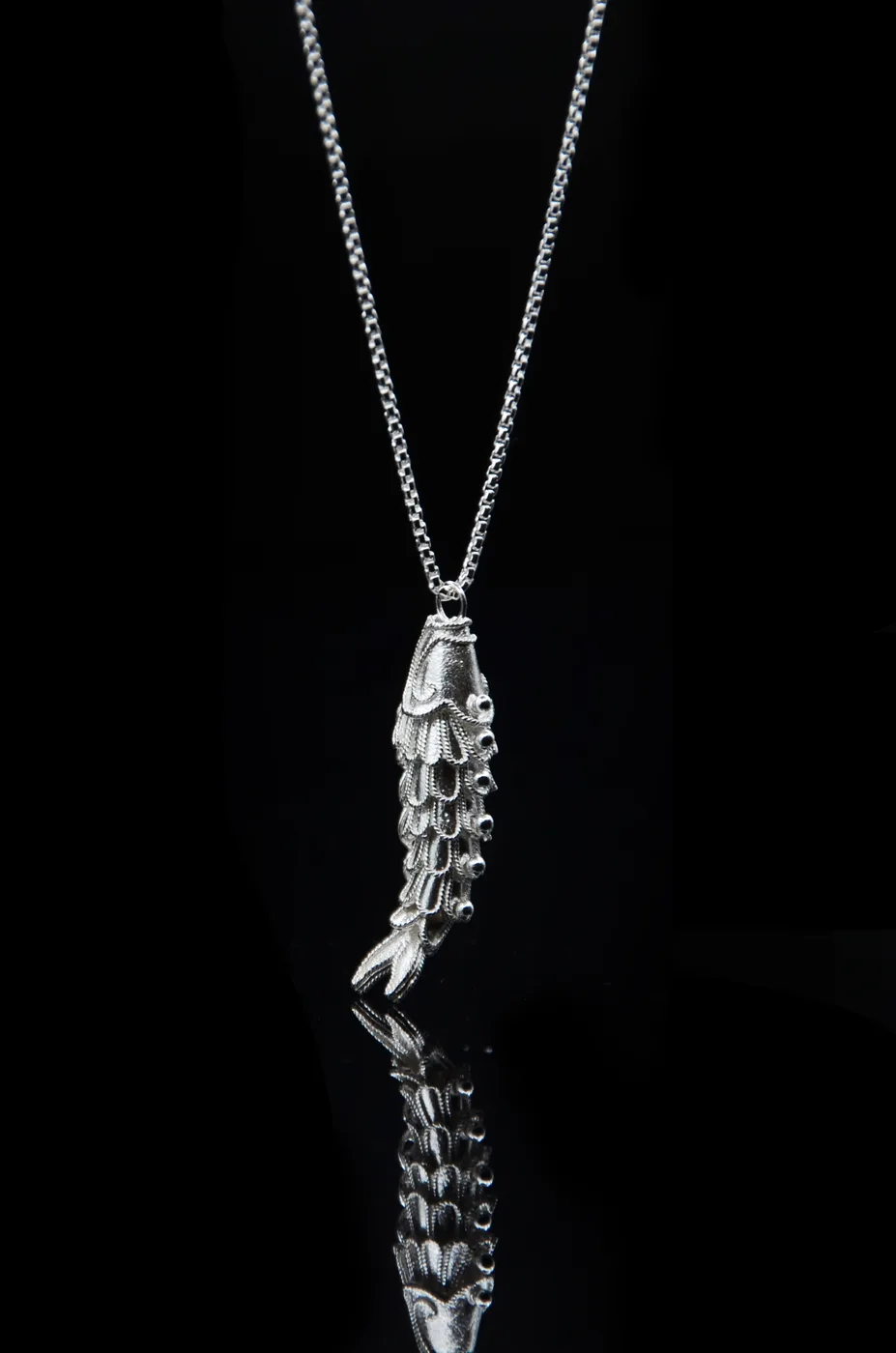 An articulated filigree fish whose silver wirework body flexes and moves.