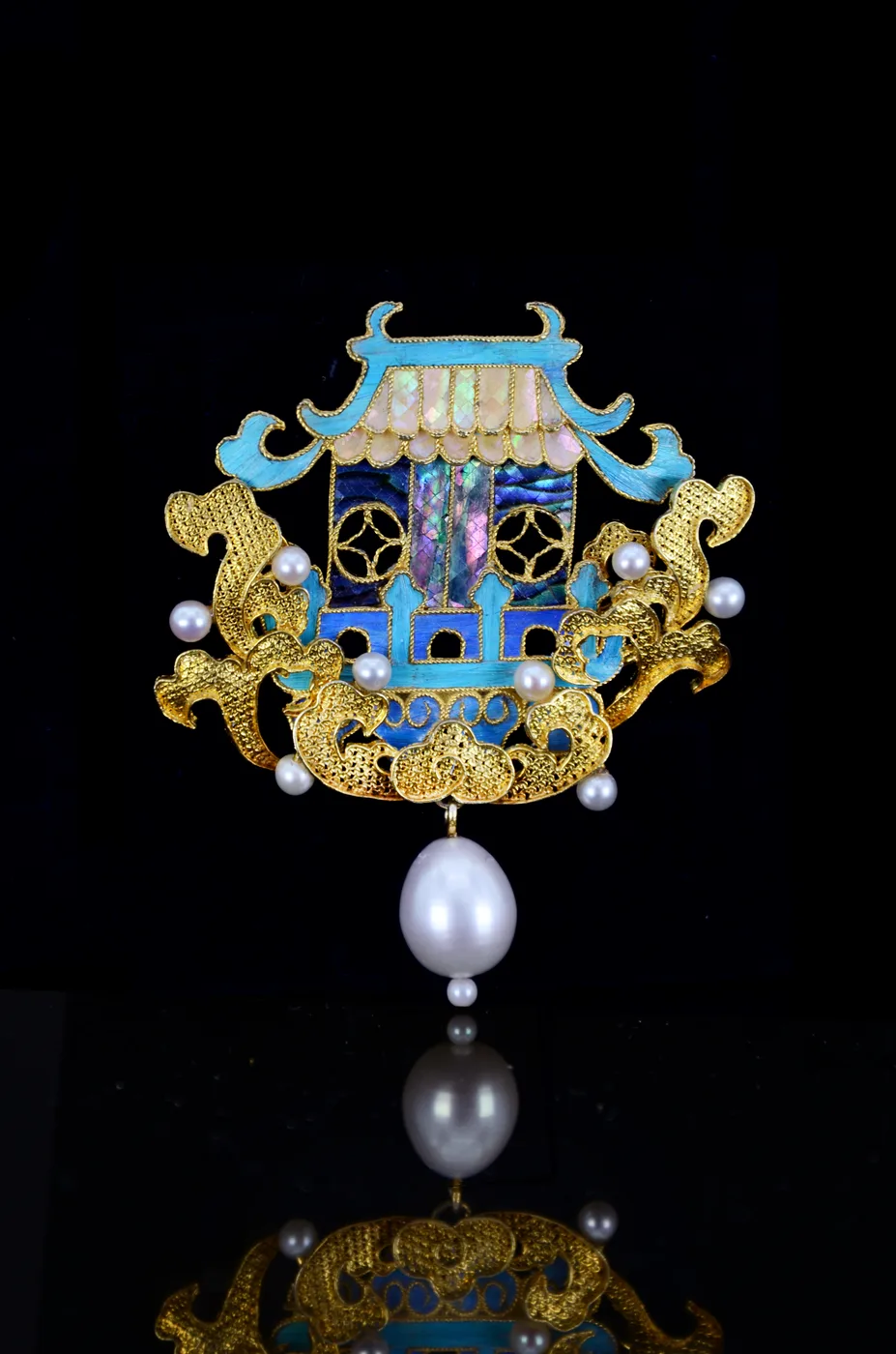 The Oriental Palace on the Sea brooch: filigree and blue feather inlay forming a pavilion above stylised waves.