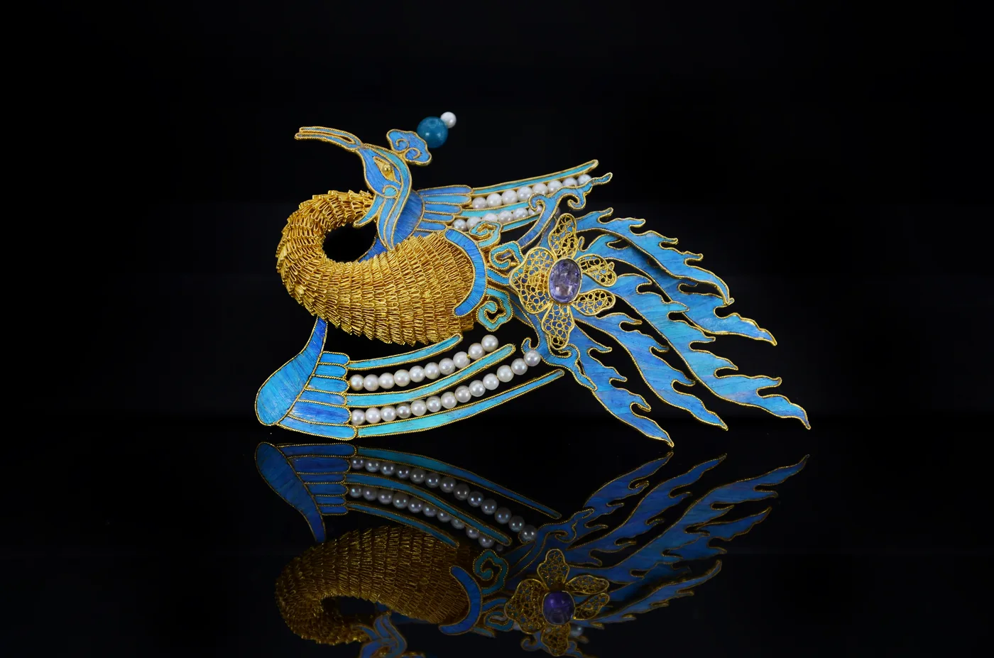 Yuyi Cheng’s Soaring Phoenix brooch: a gold filigree phoenix with blue dian cui feather inlay, set with pearls and coloured stones.