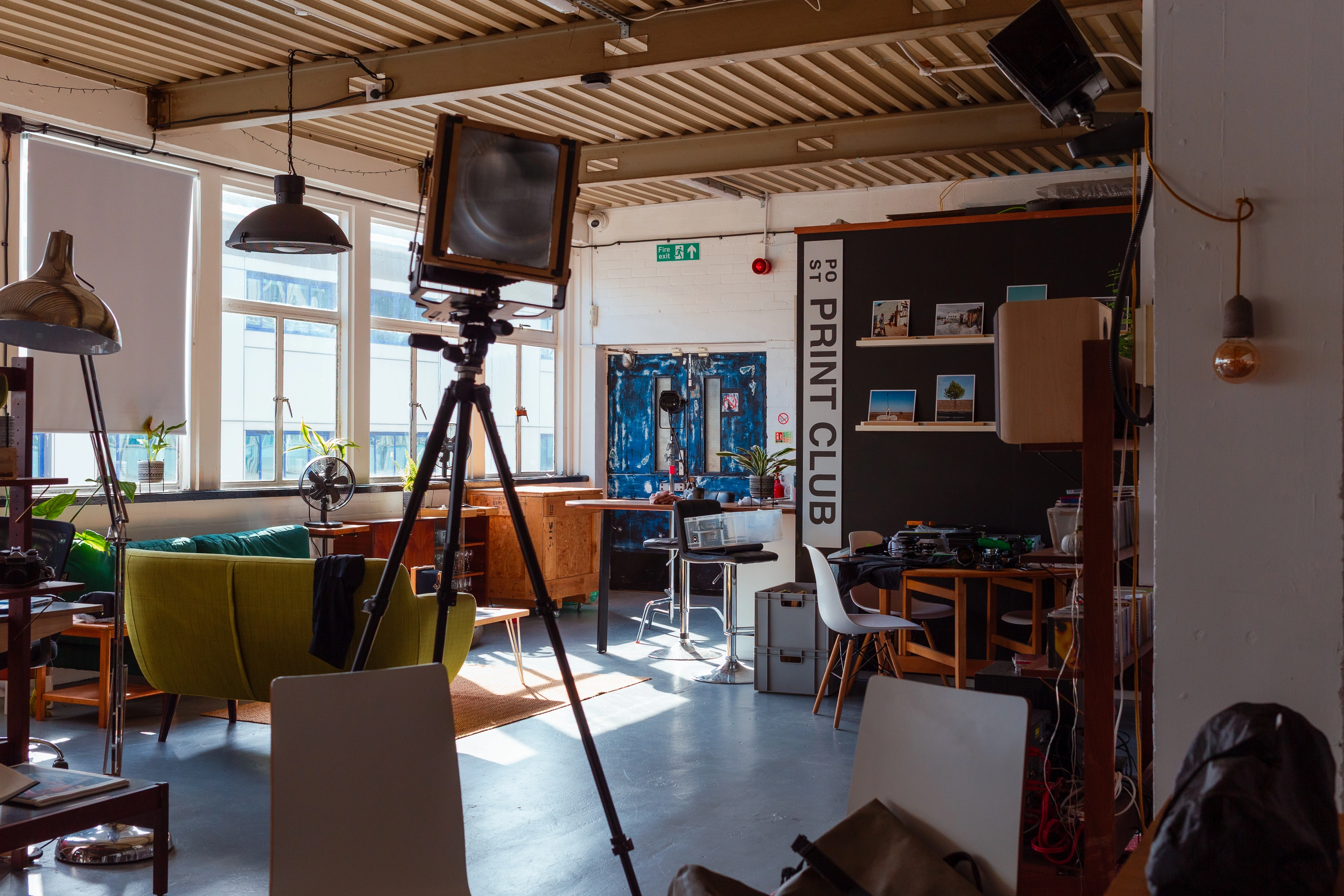 Wide view of the POST studio with the large format camera set up, natural light from the windows casting across the floor