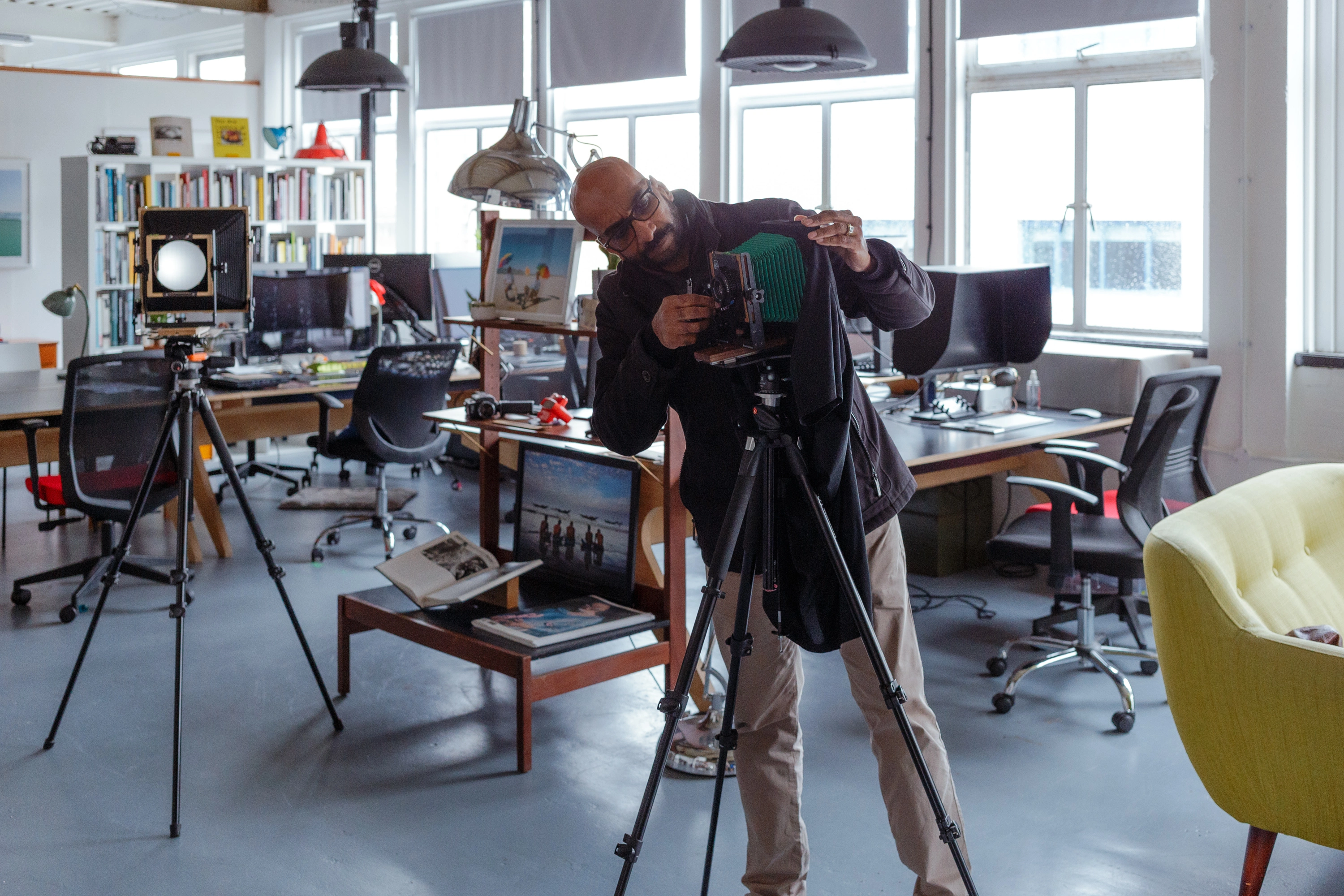 Adjusting the camera in the studio workspace, surrounded by prints, books, and other large format equipment - the learning environment