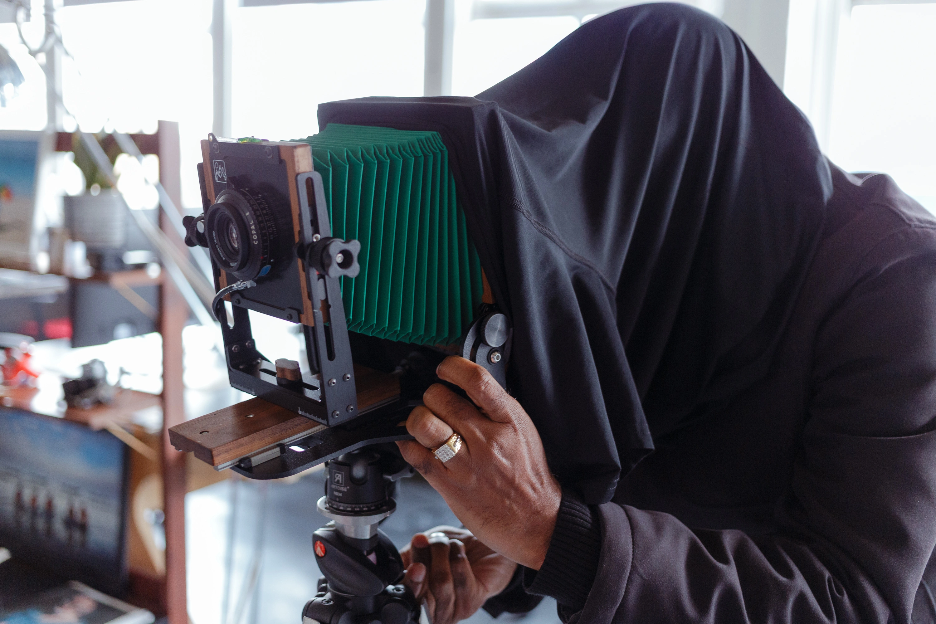 Close-up of hands adjusting the lens on the large format camera - setting aperture and focus on the green-bellows Intrepid