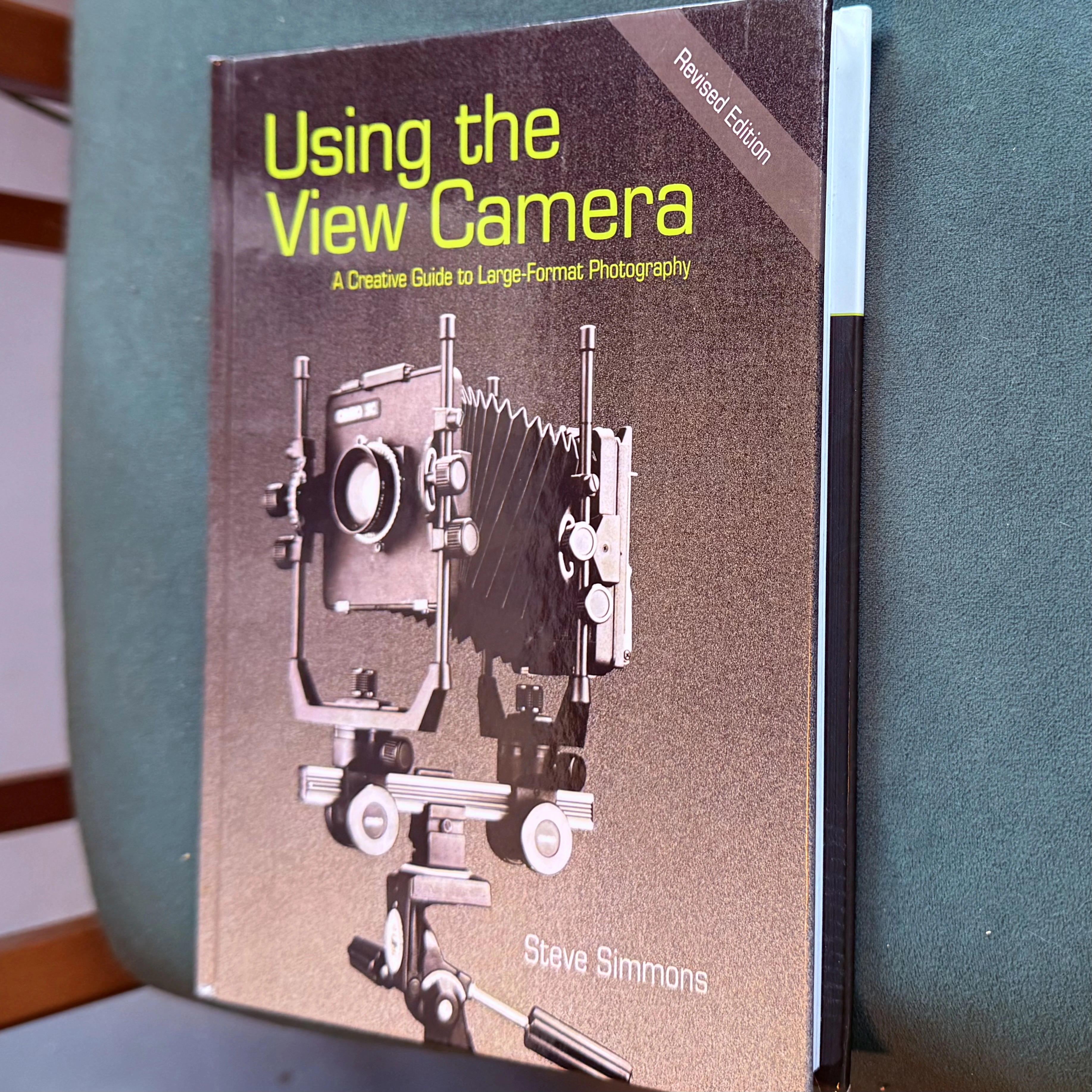 Using the View Camera by Steve Simmons, revised edition, resting on a green surface